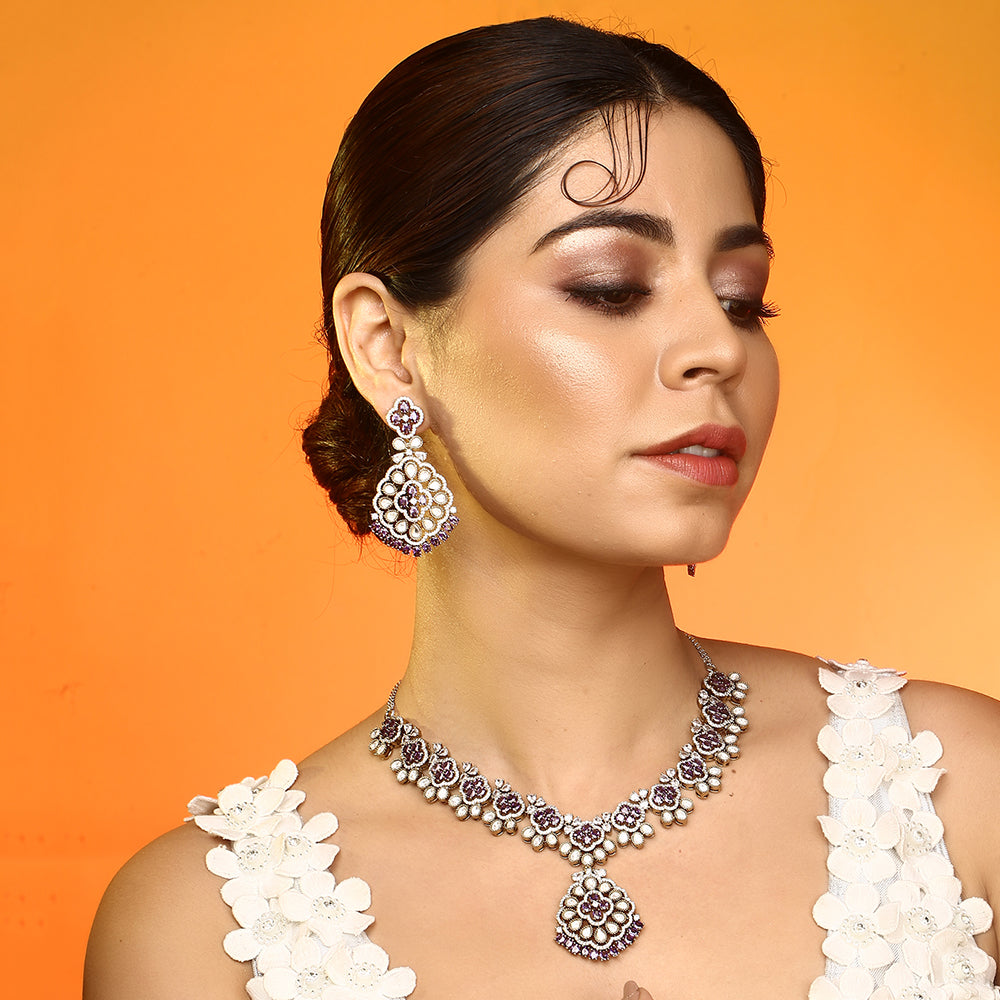 Silver plated necklace set with purple stones and matching earrings featuring intricate floral design for party and bridal wear