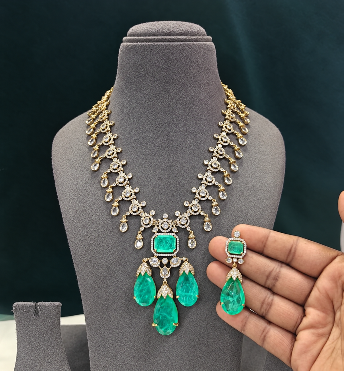 Gold plated emerald green American diamond necklace set with pear-shaped drops and matching drop earrings on