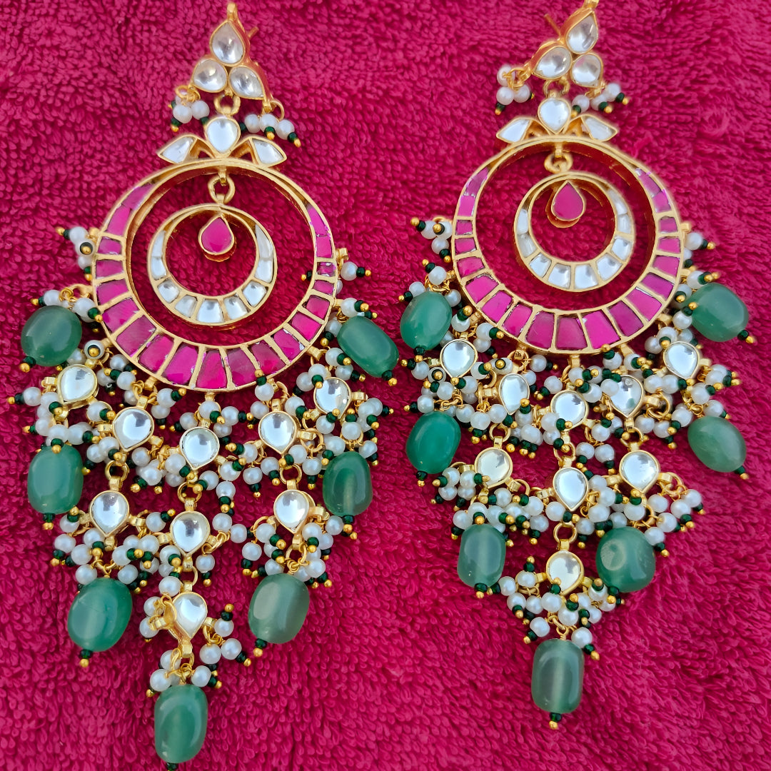 Pink meenakari Kundan chandbali earrings with green stone beads and pearl drops in antique gold finish for women.