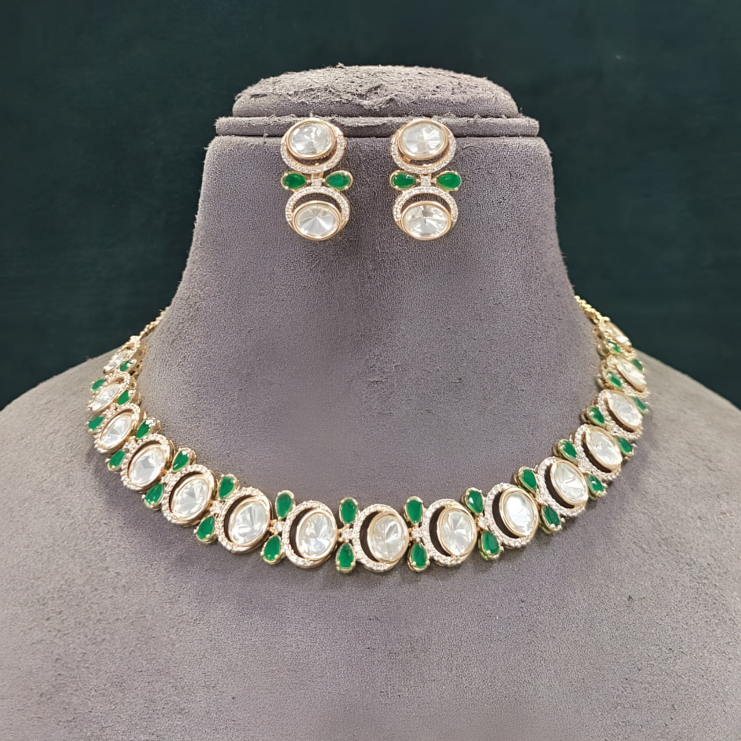Gold-tone green kundan choker necklace set with oval kundan stones, green pear-shaped accents and matching stud drop earrings on a grey display bust