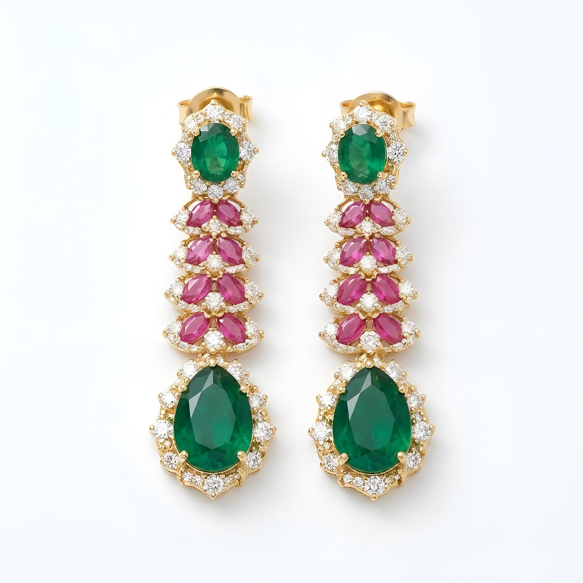Gold-tone American diamond long drop earrings with emerald-green oval tops, ruby-pink marquise leaf rows and large emerald-green pear drops on dark green velvet