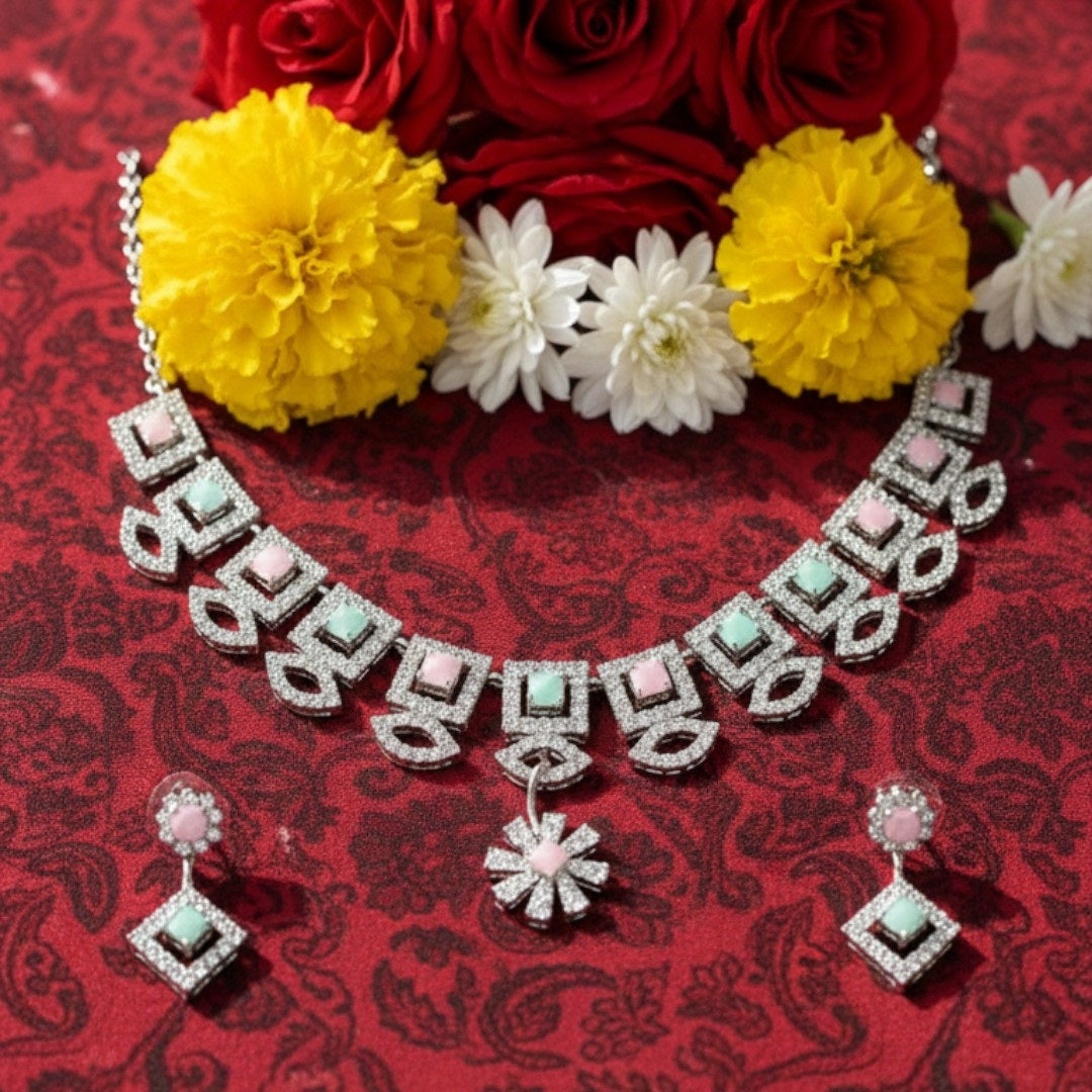 "Geometric pastel stone necklace and earring set displayed on a black velvet stand with floral centerpiece"