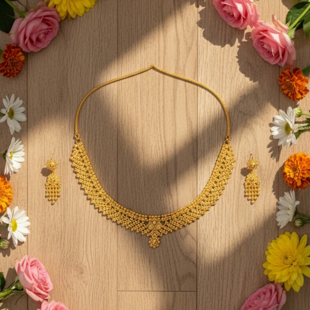 Elegant gold-plated necklace set with pearl-style bead design and matching earrings displayed on a red velvet stand.