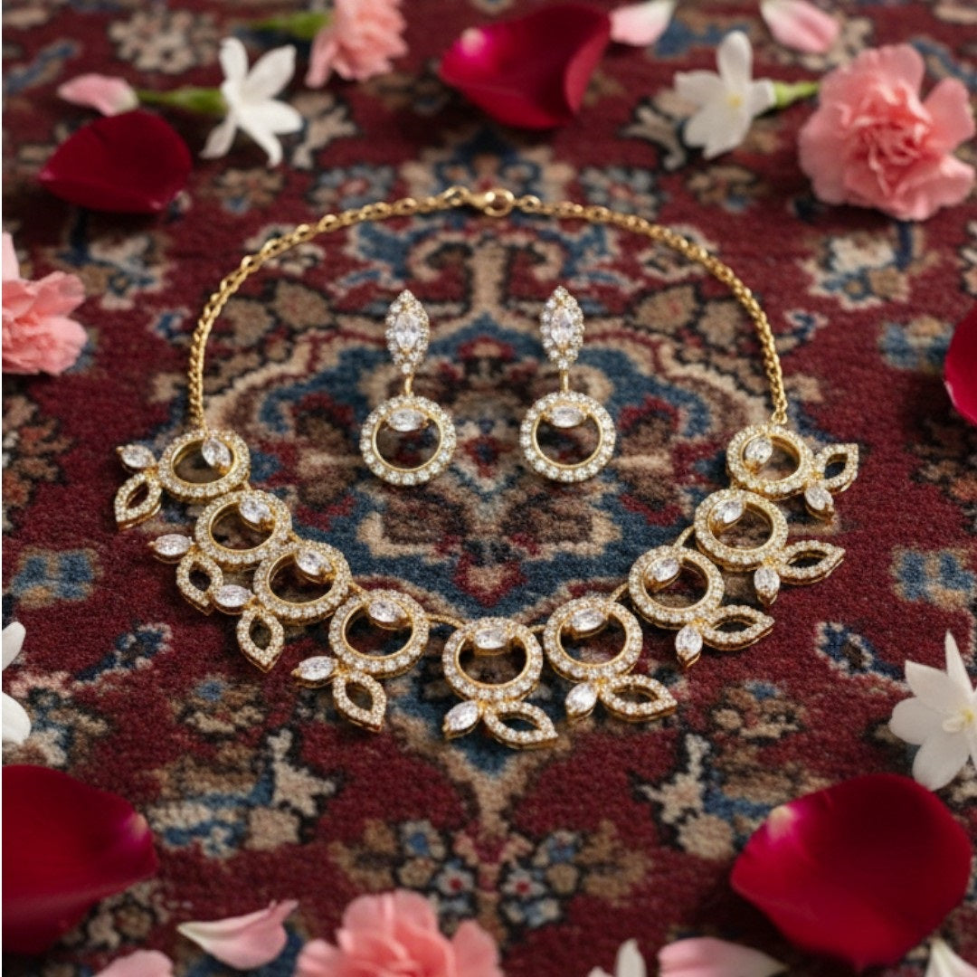 "Gold-tone necklace and earring set with circular and leaf motifs displayed on black velvet stand"