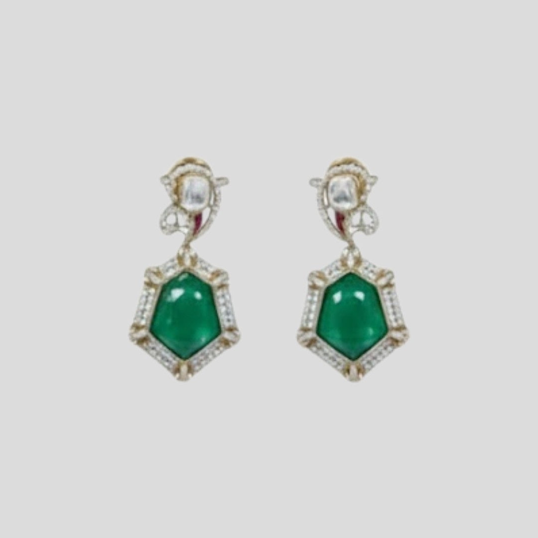 "Gold-finish necklace set with emerald green stones, white American Diamond detailing, red accents, and matching drop earrings displayed on a light background."