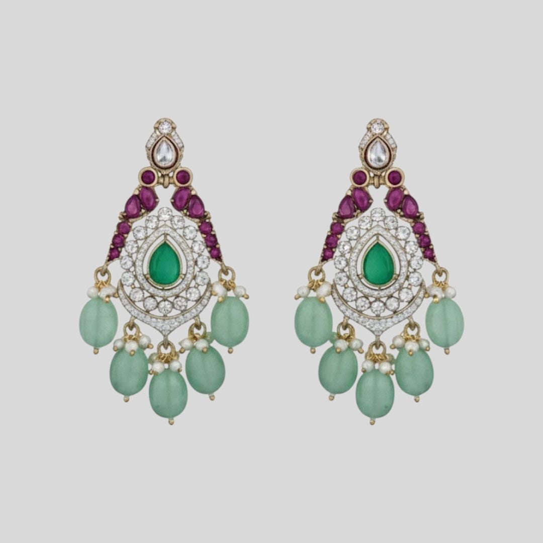 "Triple-layer gold-finish necklace set with green stones, purple detailing, American Diamond accents, pastel green bead drops, and matching earrings displayed on a light background."