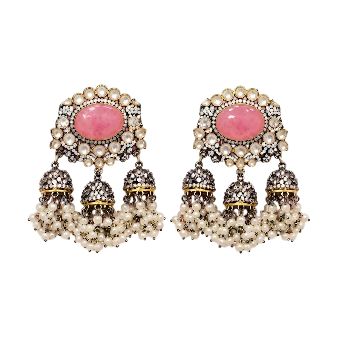 Pink Kundan jhumka earrings with antique gold finish, oval pink stone, sparkling Kundan crystals, and pearl tassel drops for bridal and festive wear.