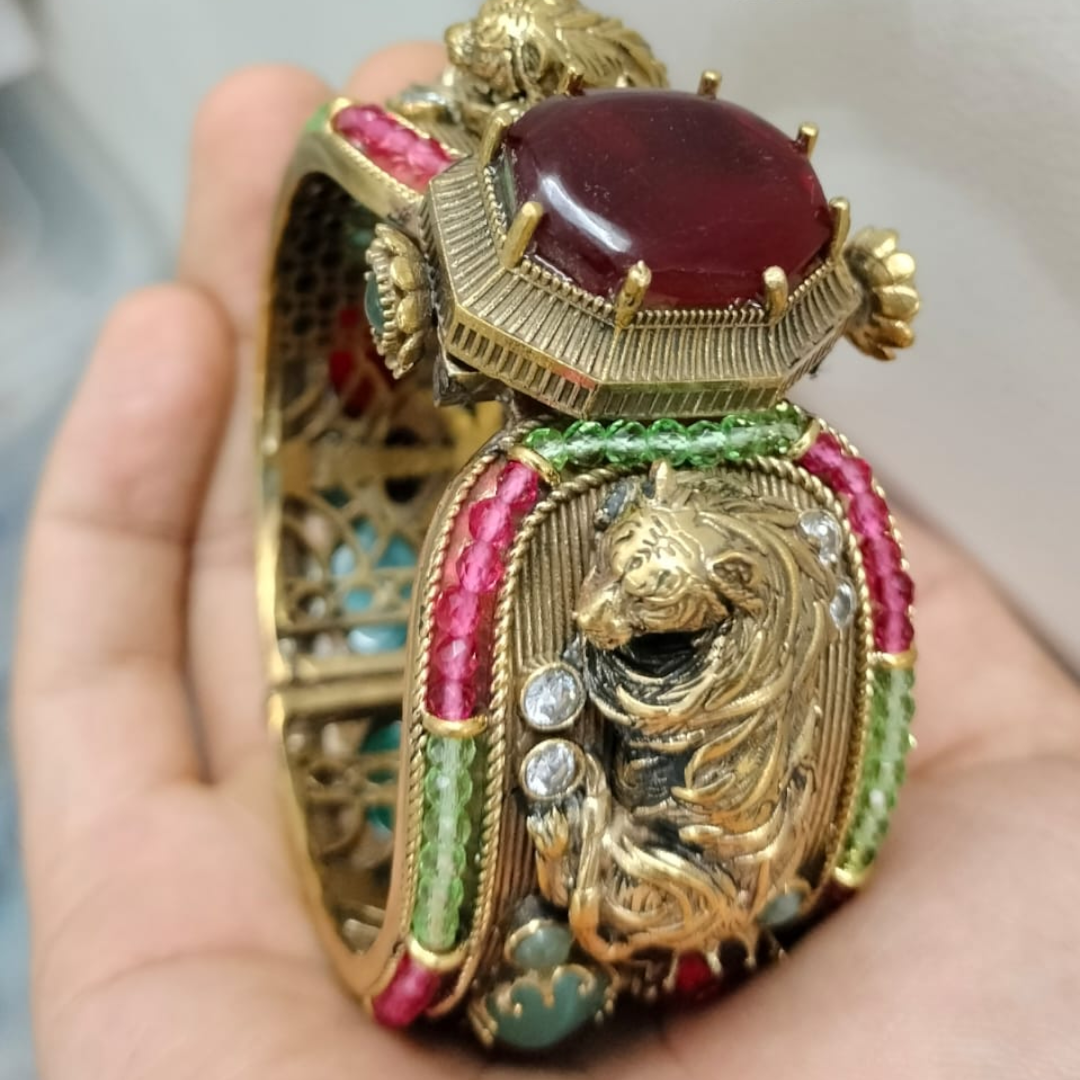 Antique gold-plated lion motif bangle with ruby centerpiece and colorful gemstones