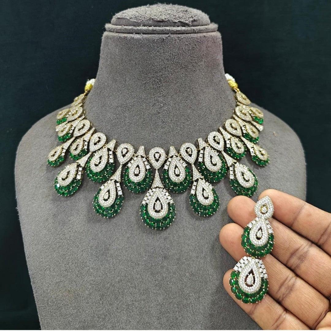 Victorian-style American diamond choker necklace set with emerald-green teardrop motifs and matching drop earrings on a grey display bust