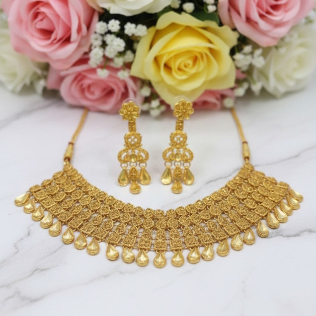 Royal gold plated bridal necklace set with matching earrings and maang tikka displayed on red velvet stand