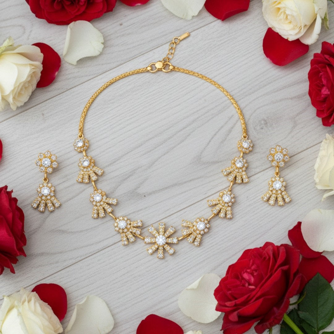 "Gold-plated floral necklace set with stone-studded motifs and matching earrings displayed on black stand – ideal for weddings and festive wear."