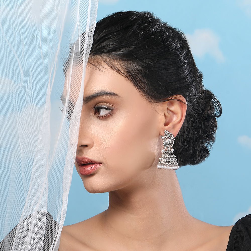 Buy Aviana Silver - Plated Crystal Studded Traditional Jhumka Earrings for Women - Auraa Trends - Jhumka - - Auraa Trends - Lady wearing silver - plated crystal peacock pattern jhumka earrings with pearl drops, Indian ethnic traditional jewellery