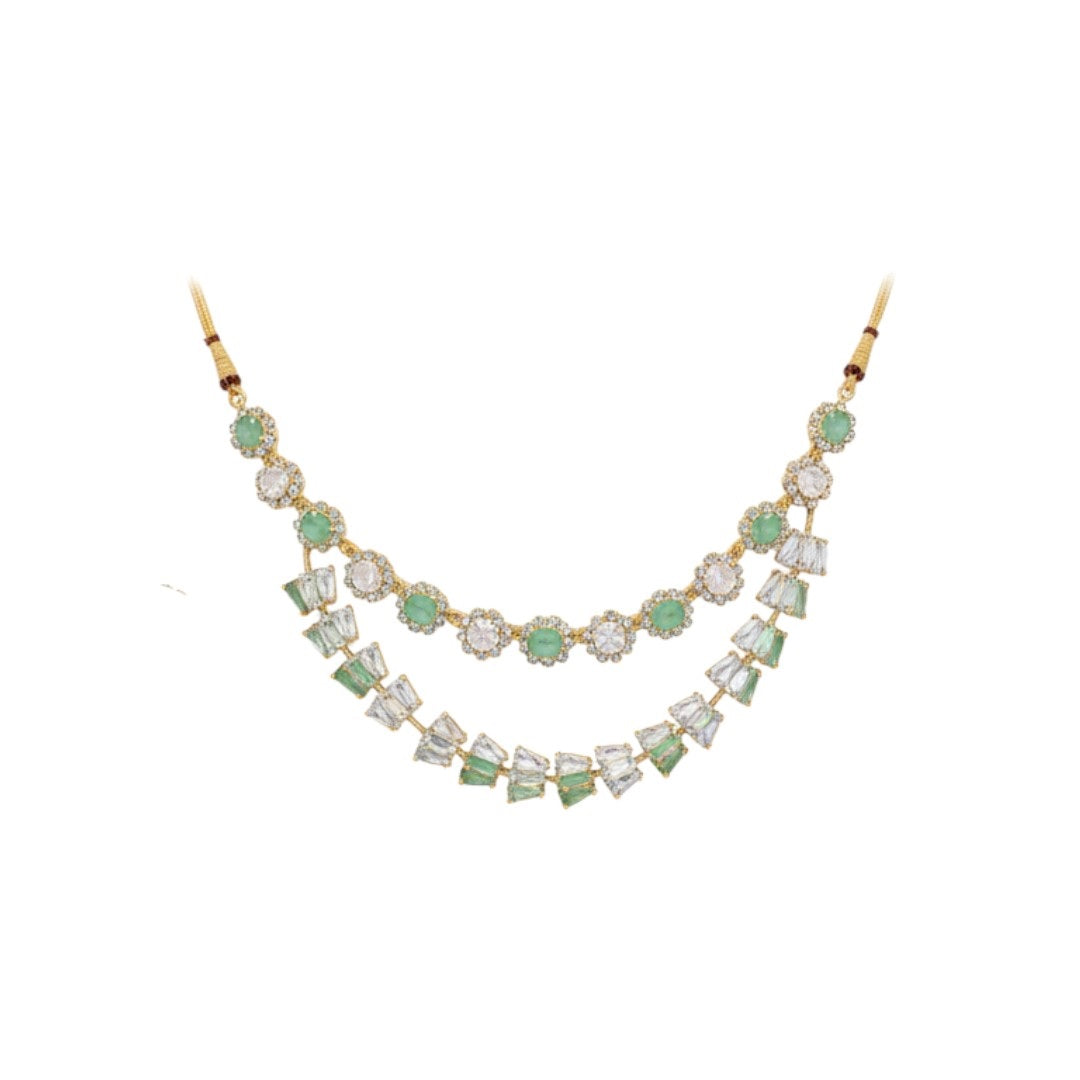 Gold-plated green and white American diamond necklace set with matching earrings on red display stand"