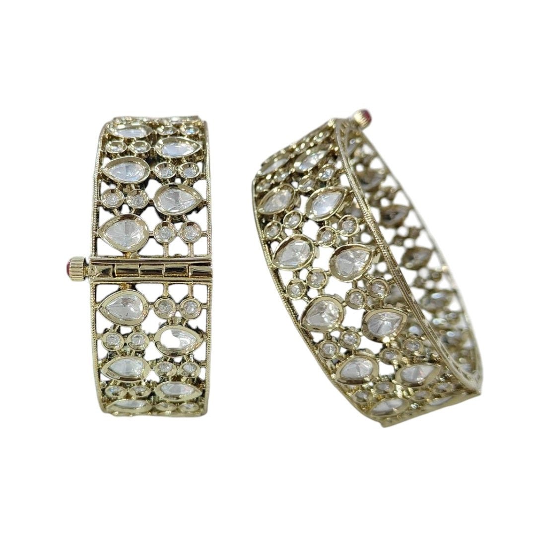 Elegant Kundan - Style Gold Plated Bangles with White Polki Stones - Auraa Trends - Bangles - - Auraa Trends - Close - up of elegant gold - plated kundan - style bangles with white Polki stones, displayed on a dark green fabric roll – traditional Indian ethnic jewelry