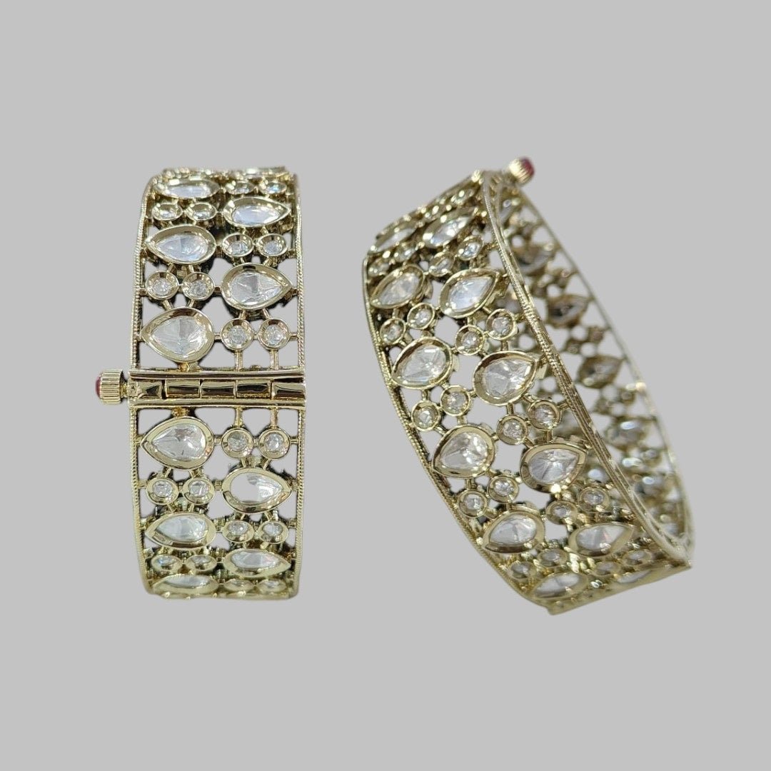 Elegant Kundan - Style Gold Plated Bangles with White Polki Stones - Auraa Trends - Bangles - - Auraa Trends - Close - up of elegant gold - plated kundan - style bangles with white Polki stones, displayed on a dark green fabric roll – traditional Indian ethnic jewelry