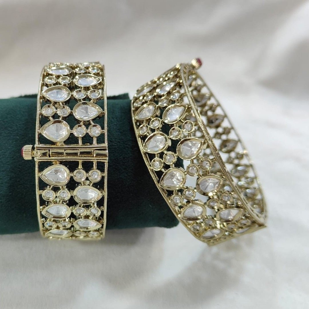 Elegant Kundan - Style Gold Plated Bangles with White Polki Stones - Auraa Trends - Bangles - - Auraa Trends - Close - up of elegant gold - plated kundan - style bangles with white Polki stones, displayed on a dark green fabric roll – traditional Indian ethnic jewelry