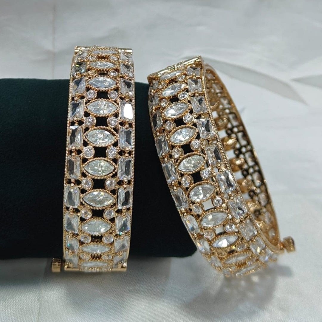 Gold - Plated Designer Bangles with Marquise & Emerald - Cut White CZ Stones - Auraa Trends - Bangles - - Auraa Trends - Close - up of gold - plated bangles adorned with marquise, emerald - cut, and round white CZ stones, displayed on a velvet roll β elegant traditional jewelry for women