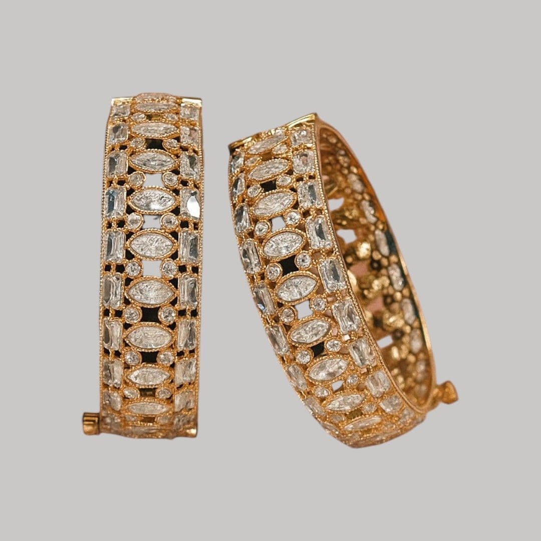 Gold - Plated Designer Bangles with Marquise & Emerald - Cut White CZ Stones - Auraa Trends - Bangles - - Auraa Trends - Close - up of gold - plated bangles adorned with marquise, emerald - cut, and round white CZ stones, displayed on a velvet roll β elegant traditional jewelry for women