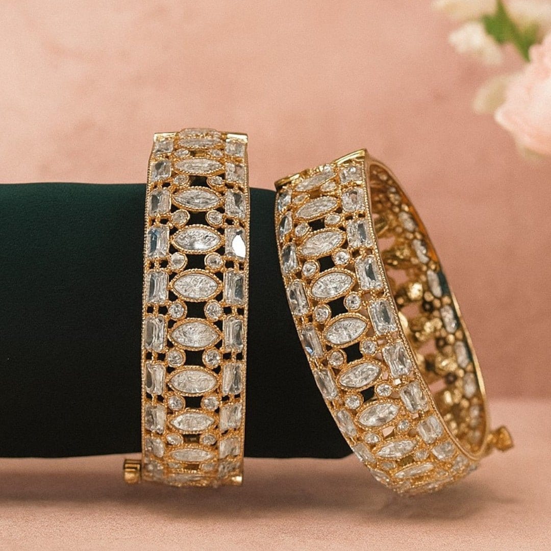 Gold - Plated Designer Bangles with Marquise & Emerald - Cut White CZ Stones - Auraa Trends - Bangles - - Auraa Trends - Close - up of gold - plated bangles adorned with marquise, emerald - cut, and round white CZ stones, displayed on a velvet roll β elegant traditional jewelry for women