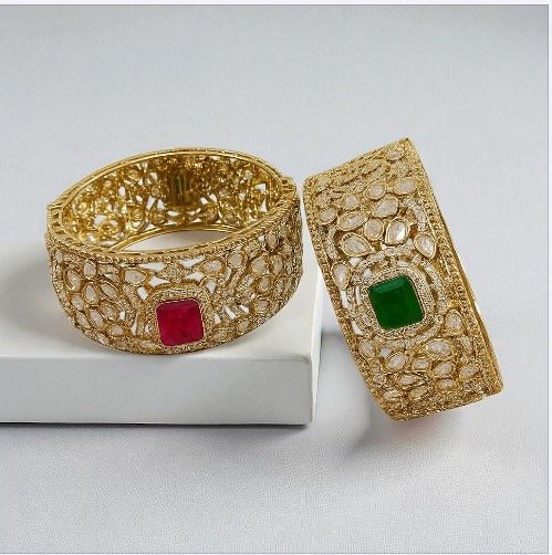 Gold - Plated Kundan Bangles with Pink & Green Square Stone - Auraa Trends - Bangles - - Auraa Trends - Pair of gold - plated traditional kundan bangles with green and pink square center stones, displayed with floral decor on textured background.โ