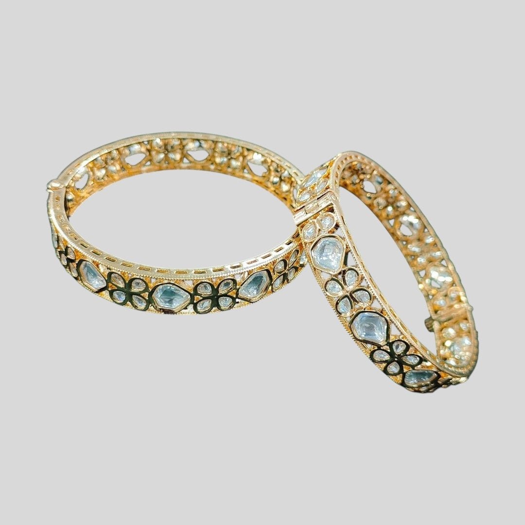 Gold - Plated Kundan Floral Bangles with White Stones - Auraa Trends - Bangles - - Auraa Trends - “Gold - plated traditional bangles with white kundan stones and floral motifs – set of 2 on green velvet background.”