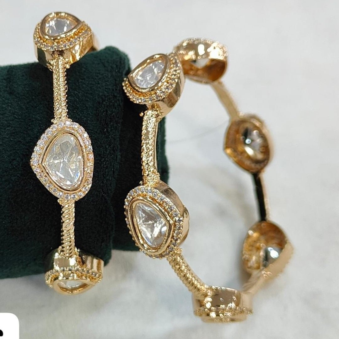 Gold - Plated Minimal Kundan - Style Open Bangles with White Stones - Auraa Trends - Bangles - - Auraa Trends - Gold - plated minimalist bangles with large white uncut - style stones and textured finish, displayed with a floral decor backdrop
