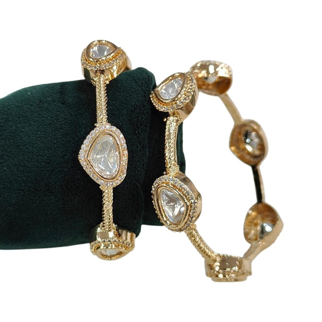 Gold - Plated Minimal Kundan - Style Open Bangles with White Stones - Auraa Trends - Bangles - - Auraa Trends - Gold - plated minimalist bangles with large white uncut - style stones and textured finish, displayed with a floral decor backdrop