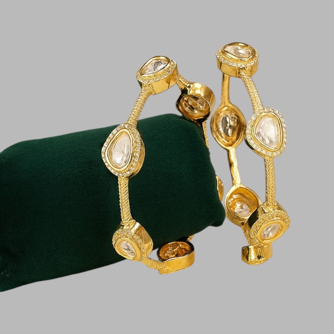 Gold - Plated Minimal Kundan - Style Open Bangles with White Stones - Auraa Trends - Bangles - - Auraa Trends - Gold - plated minimalist bangles with large white uncut - style stones and textured finish, displayed with a floral decor backdrop
