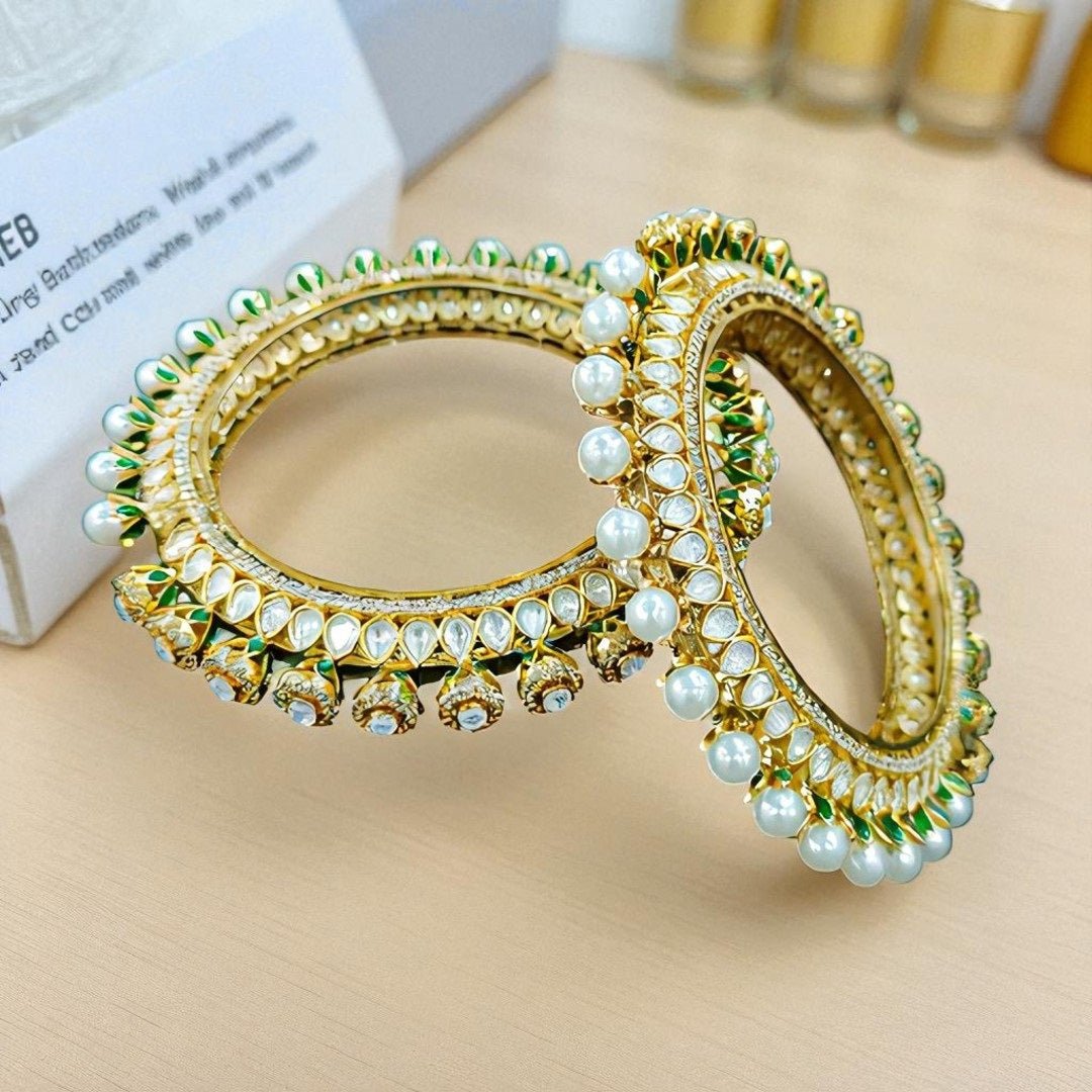 Gold - Plated Pearl & Kundan Bangles with Green Enamel Detailing - Auraa Trends - Bangles - - Auraa Trends - Gold - plated bangles with kundan stones, pearl embellishments, and jhumka - style hanging drops, displayed on dark green velvet background