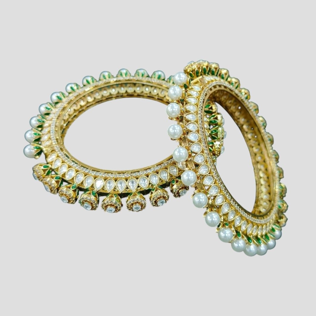 Gold - Plated Pearl & Kundan Bangles with Green Enamel Detailing - Auraa Trends - Bangles - - Auraa Trends - Gold - plated bangles with kundan stones, pearl embellishments, and jhumka - style hanging drops, displayed on dark green velvet background