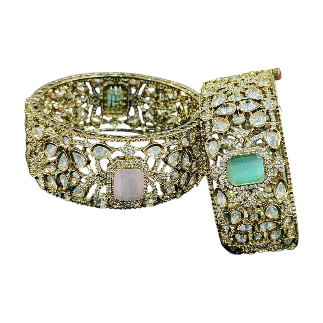 Gold - Plated Wide Kundan Bangles with Pastel Pink & Green Stones - Auraa Trends - Bangles - - Auraa Trends - โWide gold - plated kundan bangles with pastel pink and green center stones, traditional Indian bridal jewelry displayed on beige background.โ