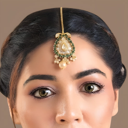 Gold-plated kundan polki paisley maang tikka with emerald green stone border, clear pear centre stone, cream pearl drop and box chain with hook