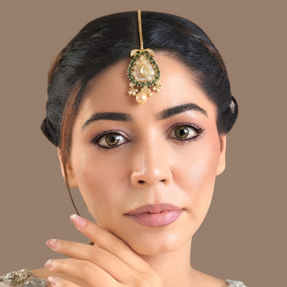 Gold-plated kundan polki paisley maang tikka with emerald green stone border, clear pear centre stone, cream pearl drop and box chain with hook