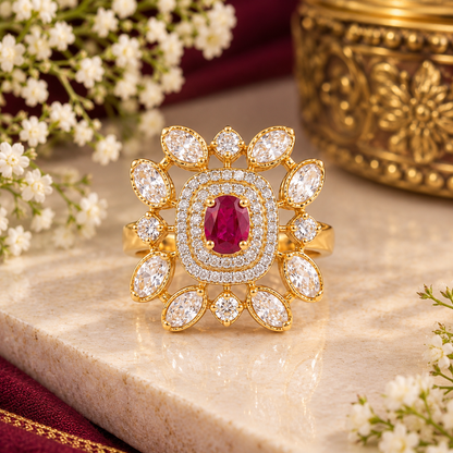 Gold-finish floral cocktail ring with a ruby-pink oval centre stone, double American diamond halo, and clear marquise-cut petal stones