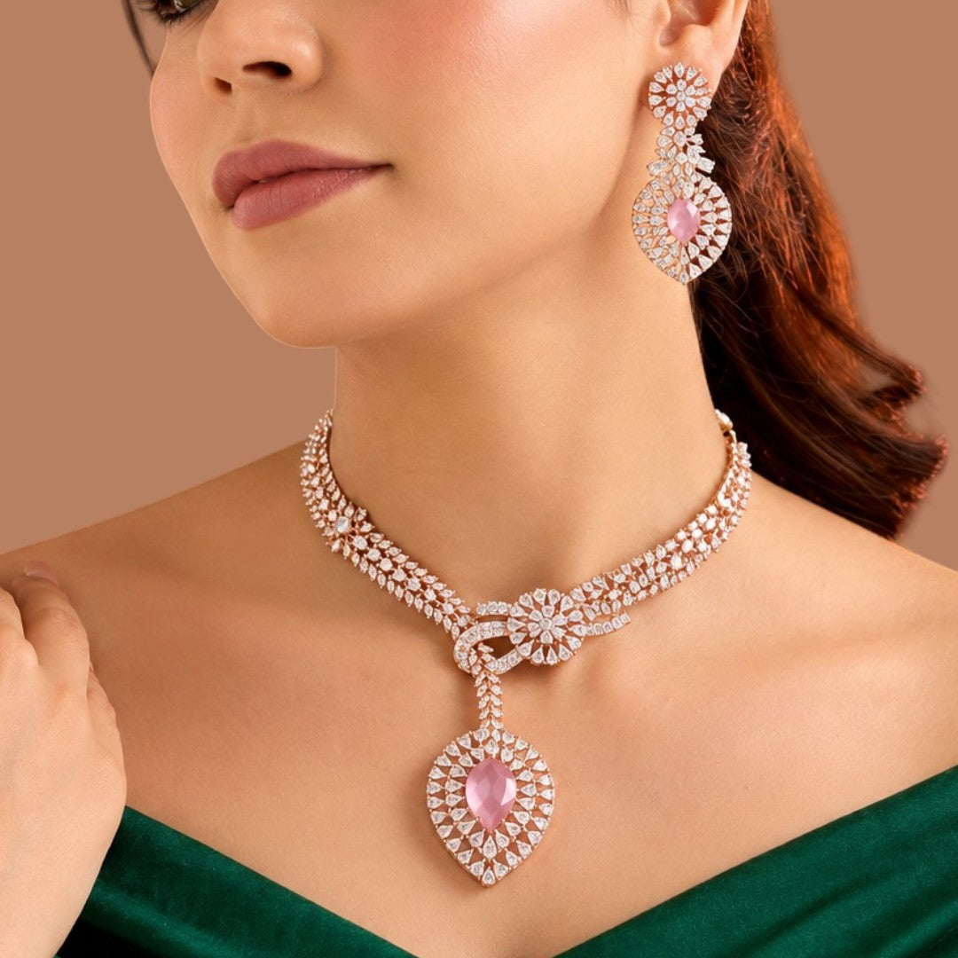 Rose gold plated pink American diamond necklace set with knot design, pink pear drop pendant and matching earrings