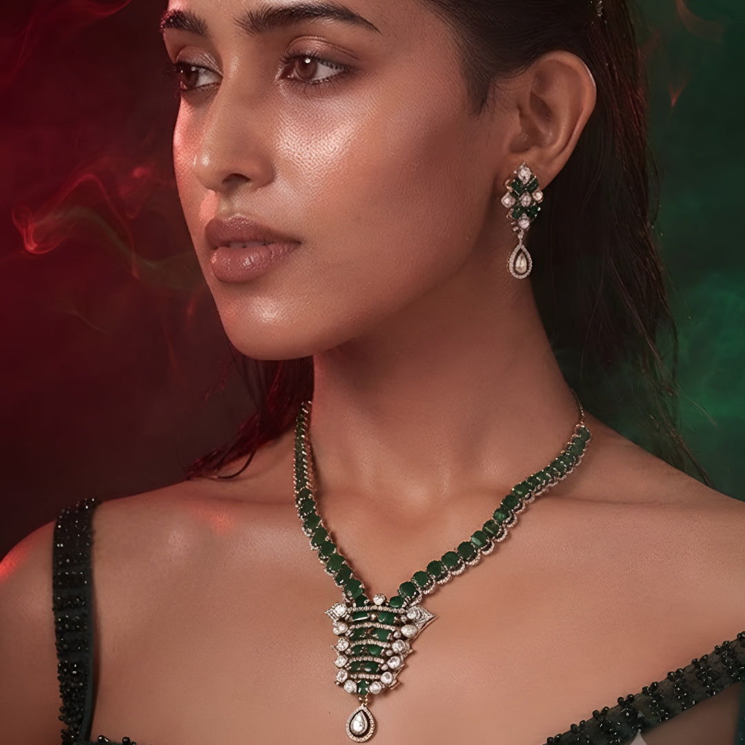 "Emerald green Kundan-style necklace and earring set with antique gold finish and white stone accents"