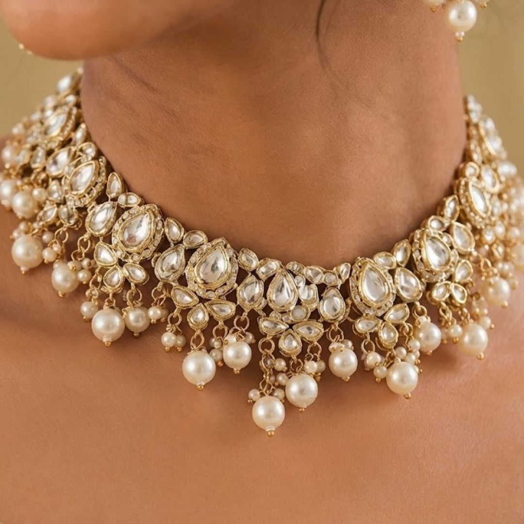 Gold-plated Kundan pearl choker necklace set with American diamond stones and matching pearl drop earrings for bridal, wedding, and festive wear.