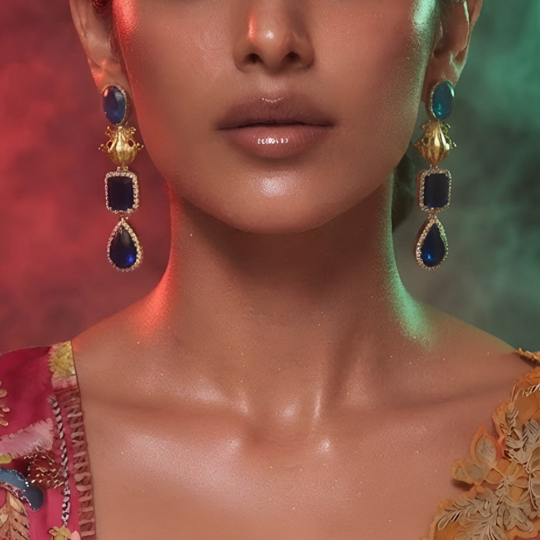 Antique gold-tone frog motif drop earrings with sapphire-blue stones and CZ halo detailing, front-facing pair