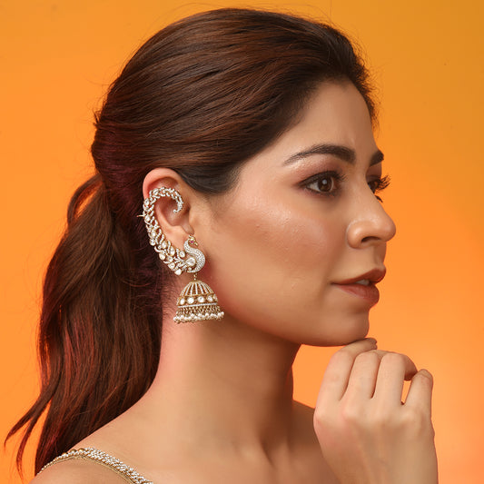 Gold plated peacock design jhumka earrings with American diamonds and pearl drops on white background