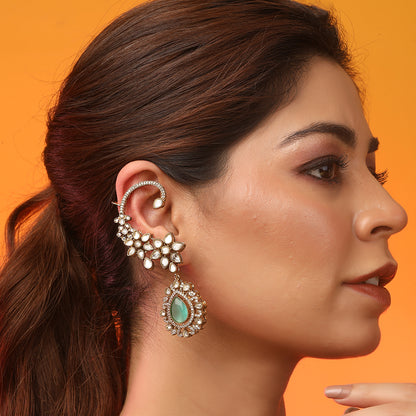Gold floral kundan ear cuff earrings with green teardrop gemstone and intricate design