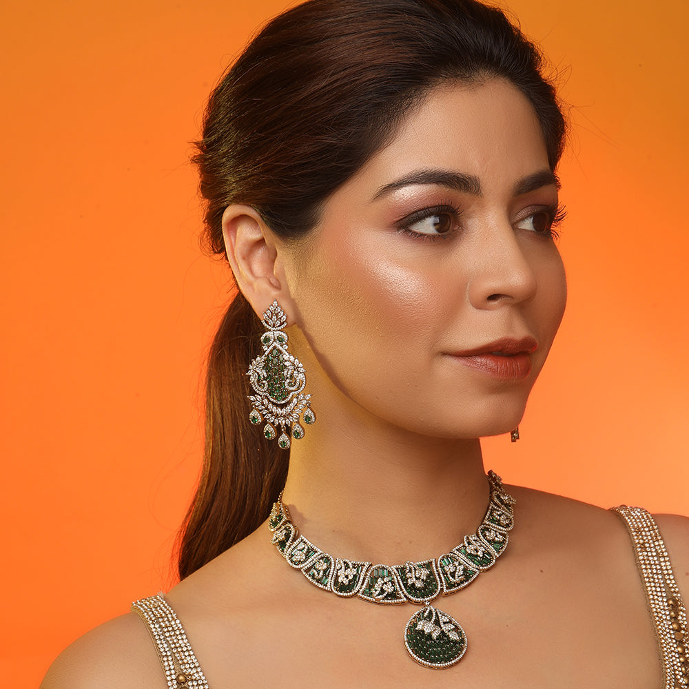 Gold plated statement necklace set with green stones and matching chandelier earrings for bridal and festive wear