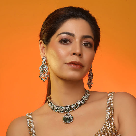 Gold plated statement necklace set with green stones and matching chandelier earrings for bridal and festive wear
