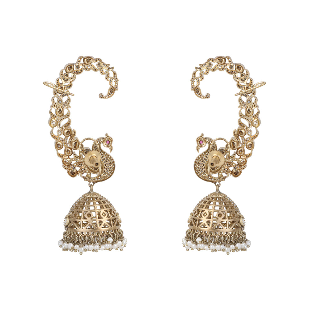 Gold plated peacock design jhumka earrings with American diamonds and pearl drops on white background