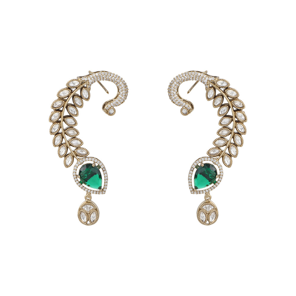 Gold plated American diamond ear cuff earrings with green teardrop stone and leaf design on white background