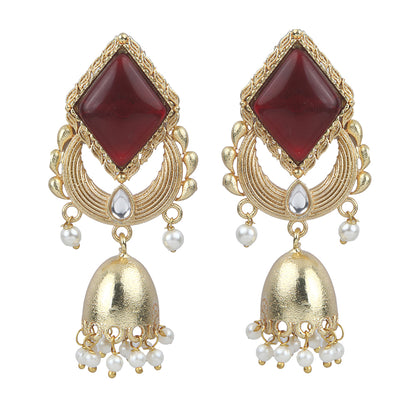 Gold jhumka earrings with red gemstone top, circular design, and pearl drop danglers on neutral background