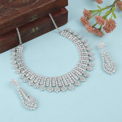 Silver American diamond necklace set with heart-shaped drop design and matching long earrings on white background