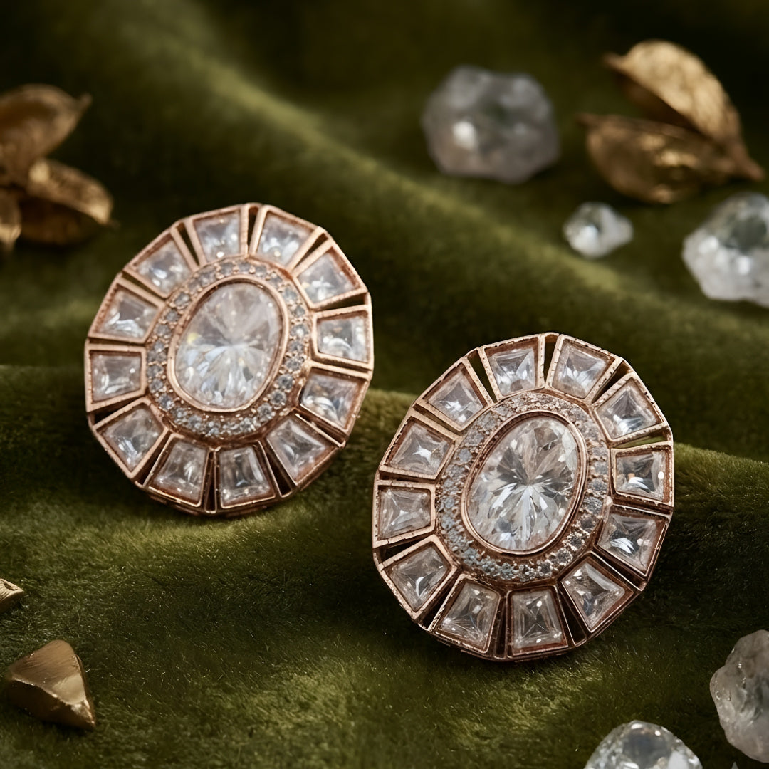 Pair of rose gold-plated oval stud earrings with white stone sunburst halo design on white