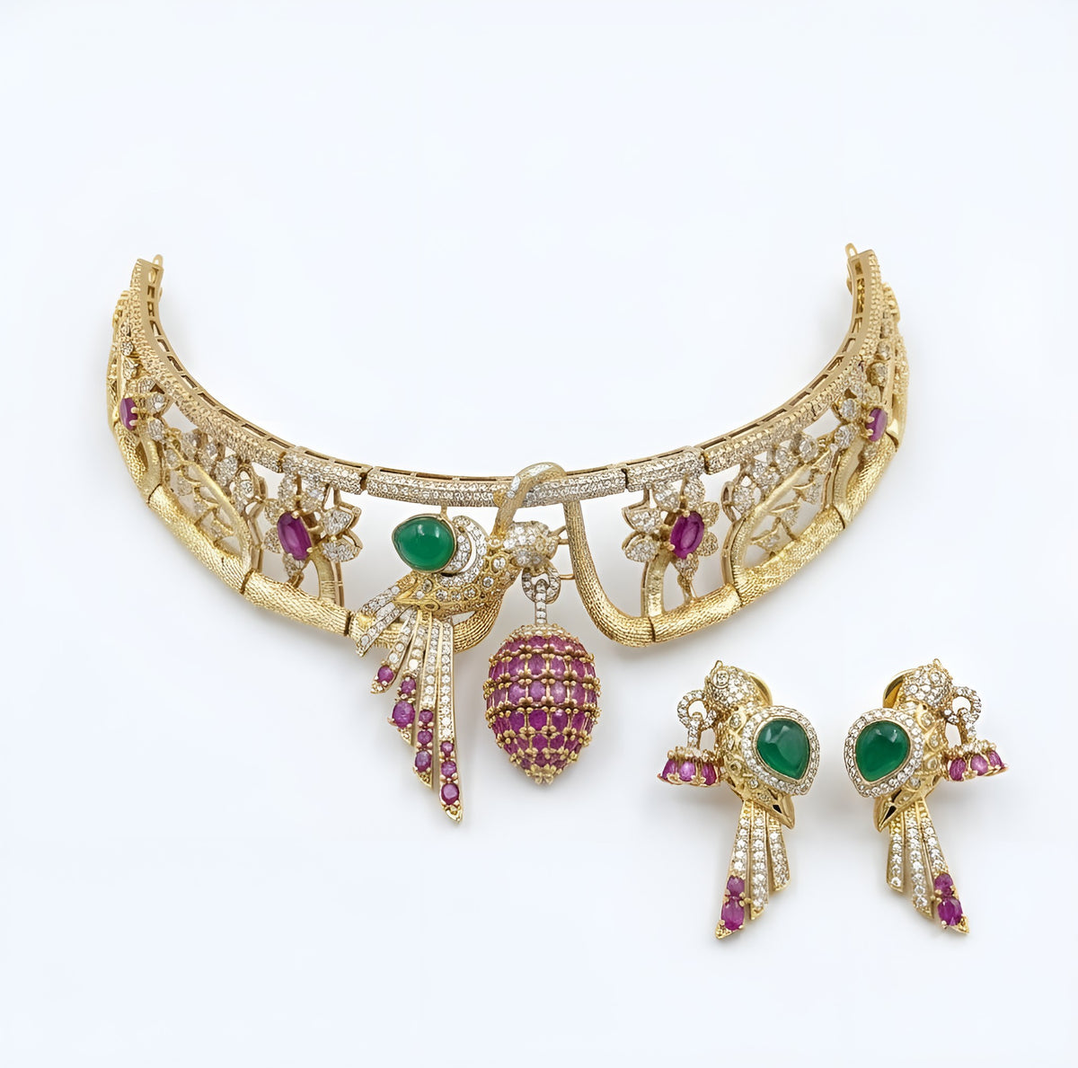 Gold-tone American diamond rigid choker with bird motif, emerald-green stone, ruby-pink flowers and ruby cage drop with matching bird earring on a grey display bust