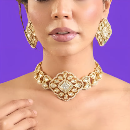 Gold plated polki kundan choker necklace set with matching diamond-shaped stud earrings held in hand