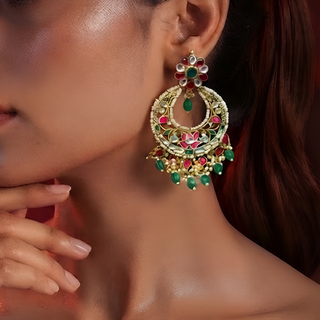 "Gold polish Kundan Meenakari chandbali earrings with pink and green stones, green bead drops and pearl fringe on mannequin display"